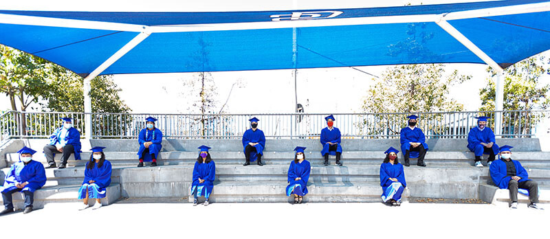 Photo of high school seniors social distancing in their caps and gowns
